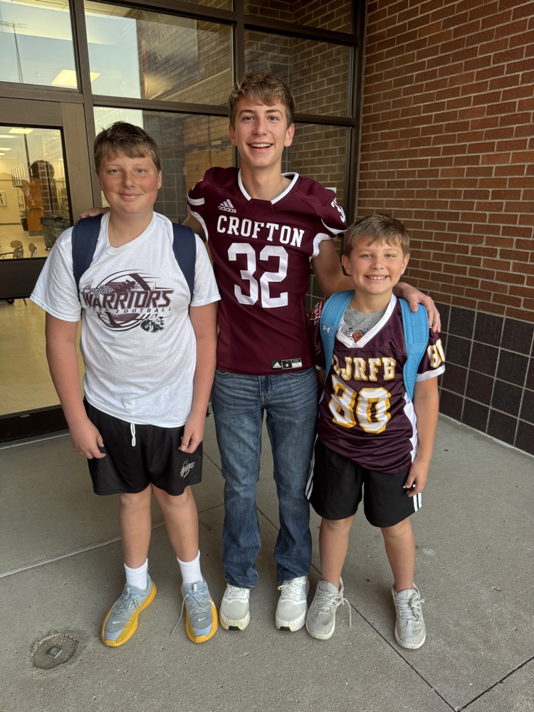 Siblings posing together for the football team High Five Friday