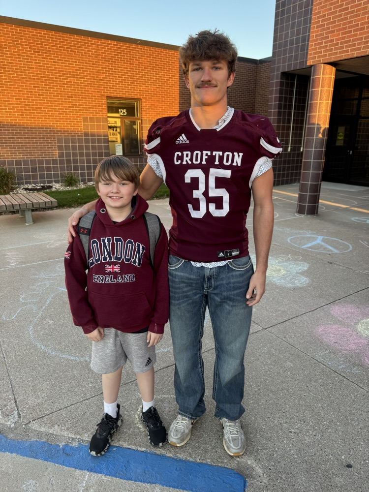 Siblings posing together for the football team High Five Friday