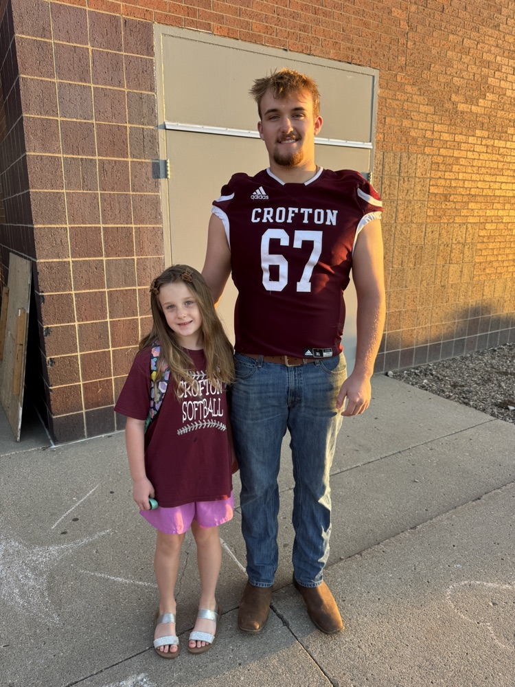 Siblings posing together for the football team High Five Friday