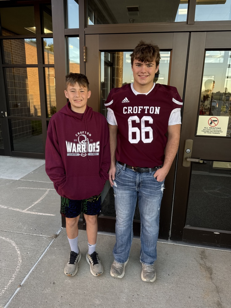 Siblings posing together for the football team High Five Friday