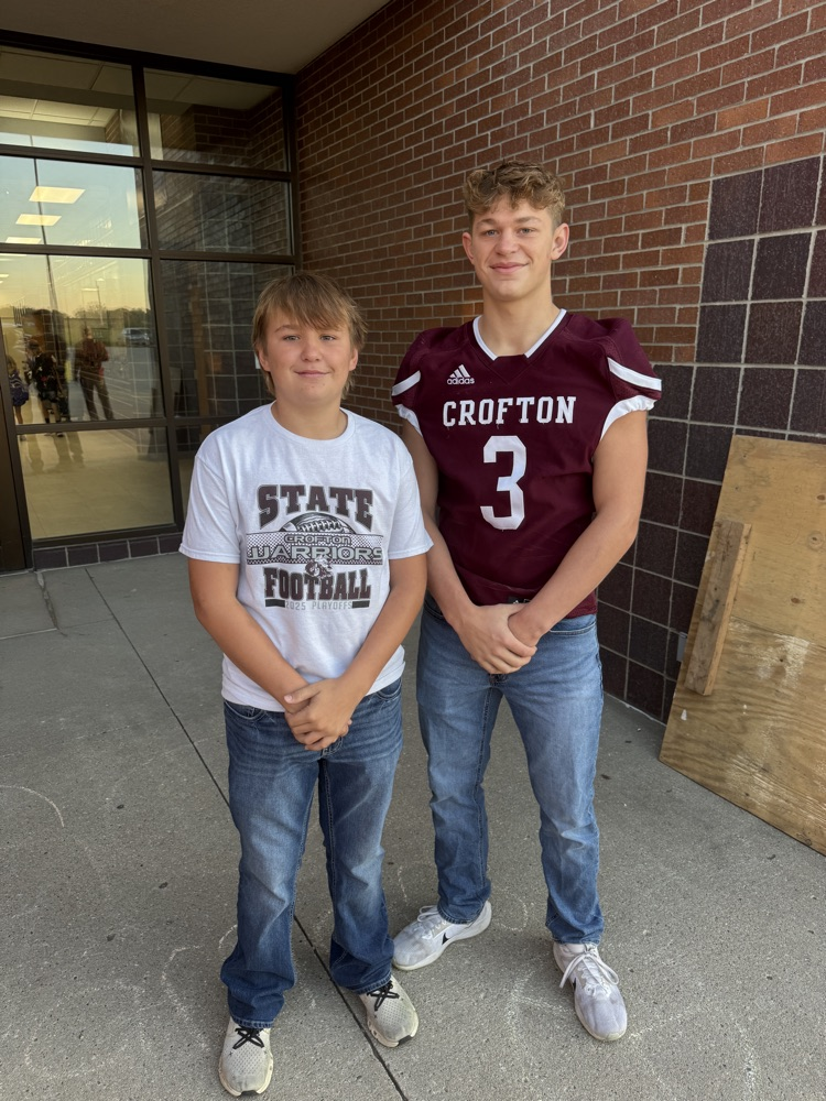 Siblings posing together for the football team High Five Friday