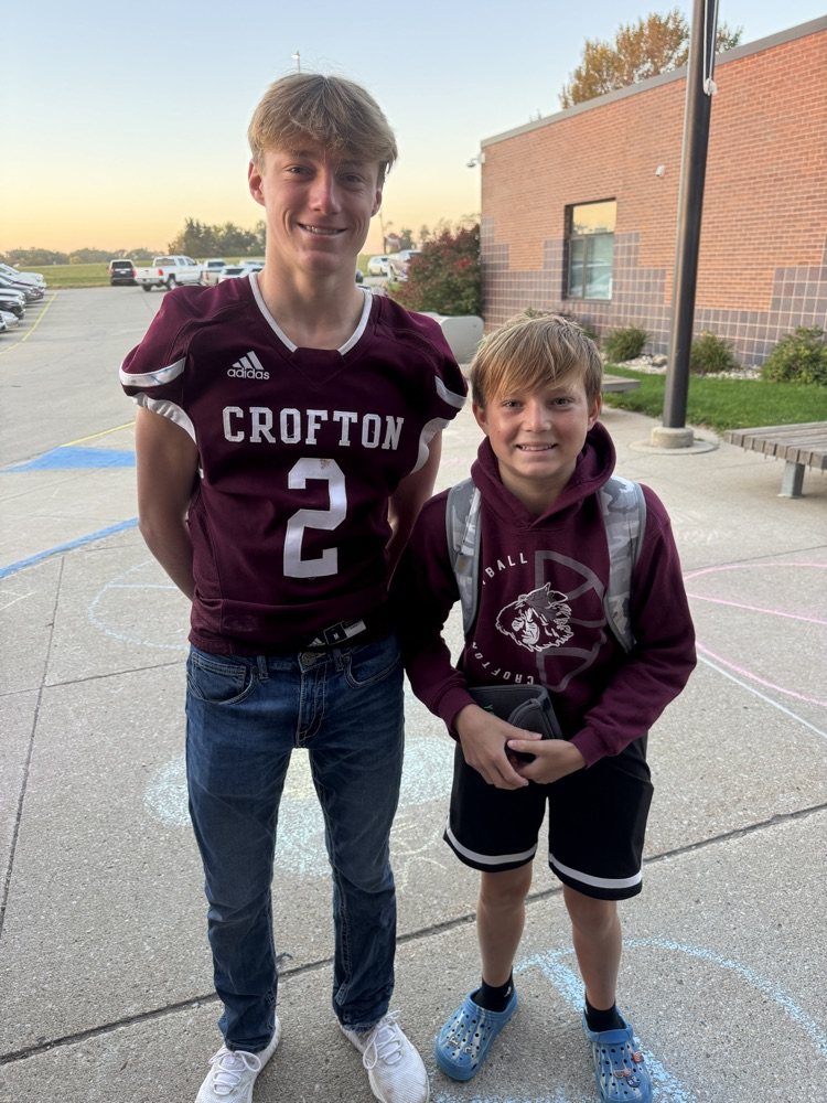 Siblings posing together for the football team High Five Friday