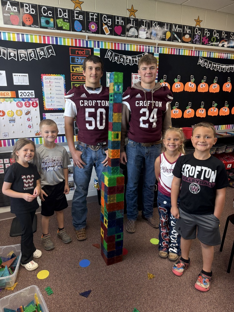 Kindergarteners and seniors together for Homecoming doing centers