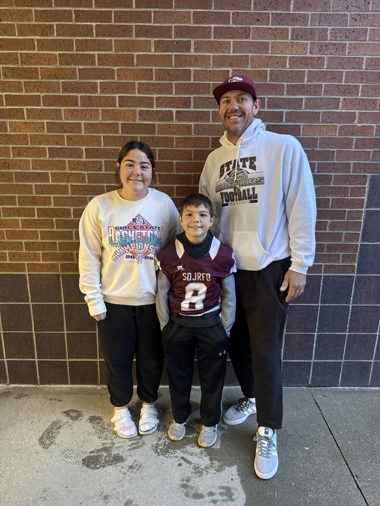Family posing together for a photo during High Five Thursday