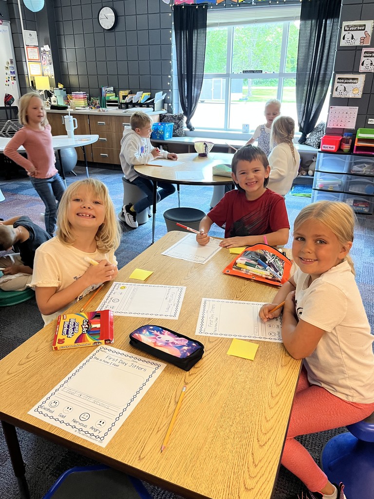 three students sitting at a table working