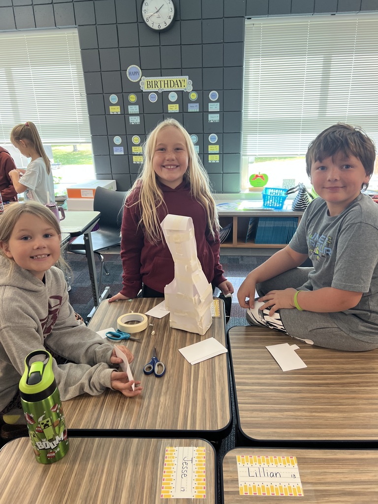 three students building with index cards