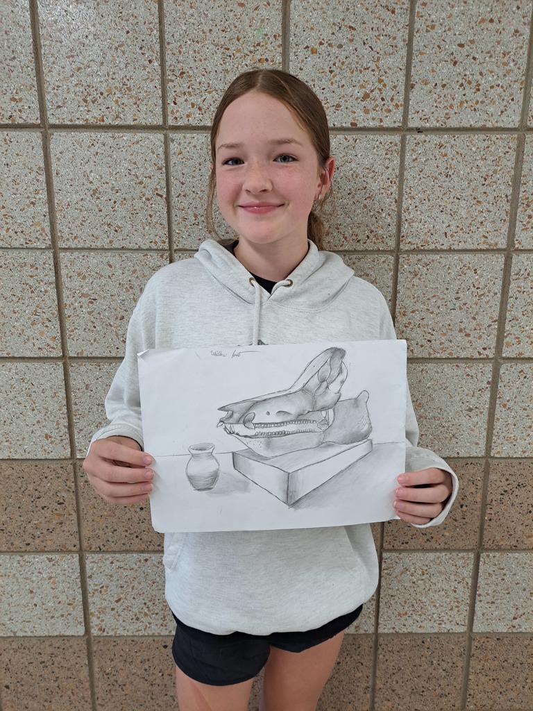 female holding a black and white still life drawing