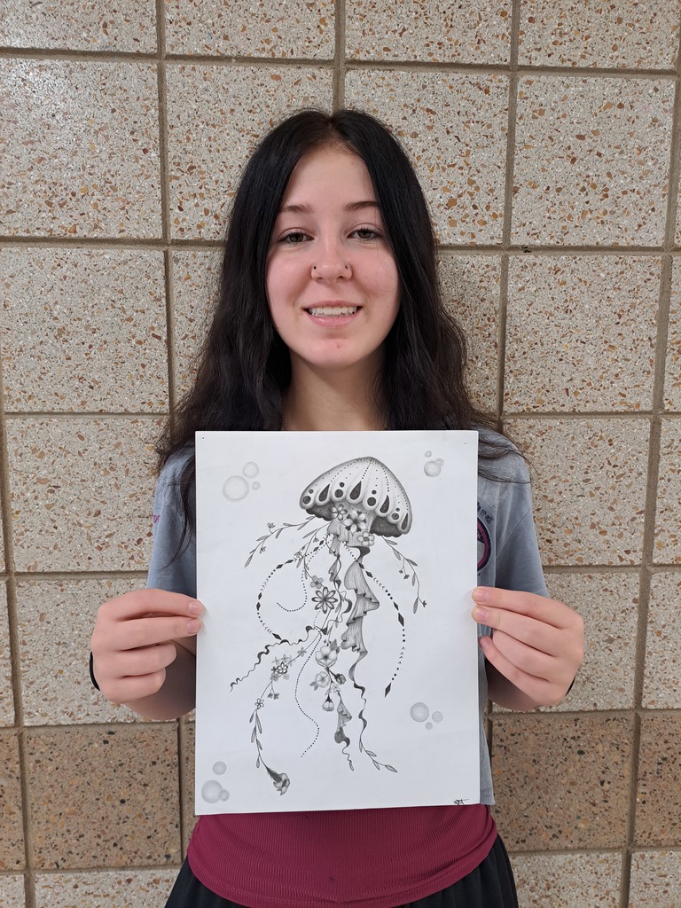 female holding a black and white drawing of a jelly fish