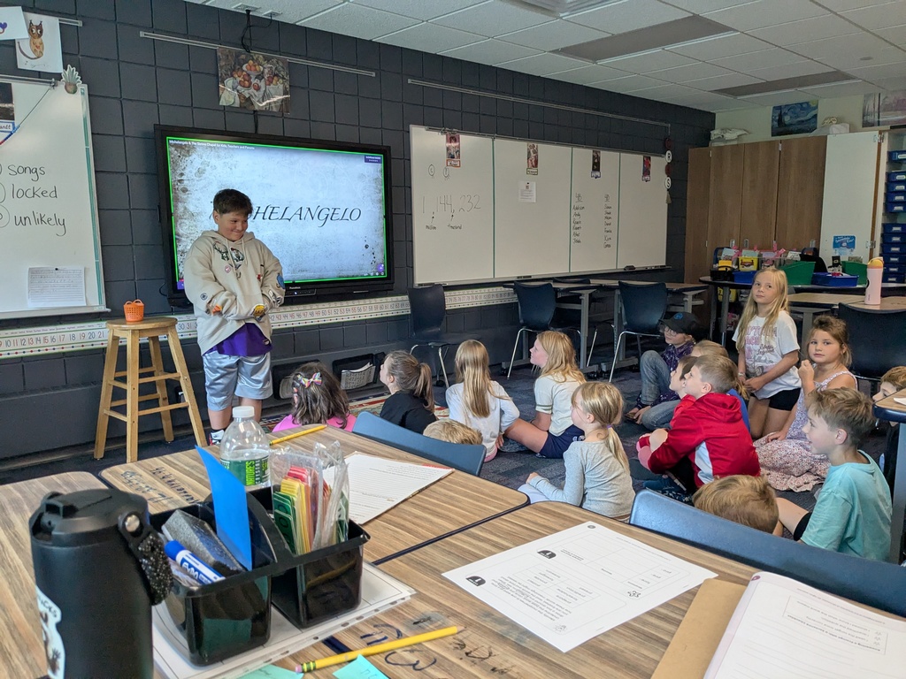 a male student standing in front of the class 