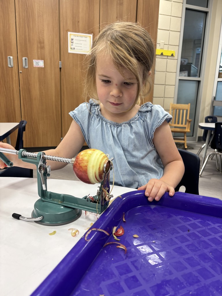 female student coring an apple at a table