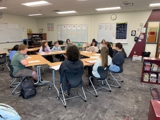 students sitting in a circle at their desks