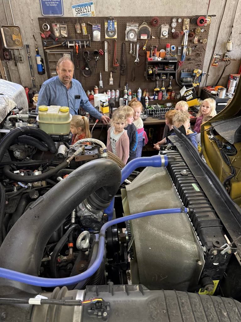 the inside of an engine of the bus with kindergartners and a driver