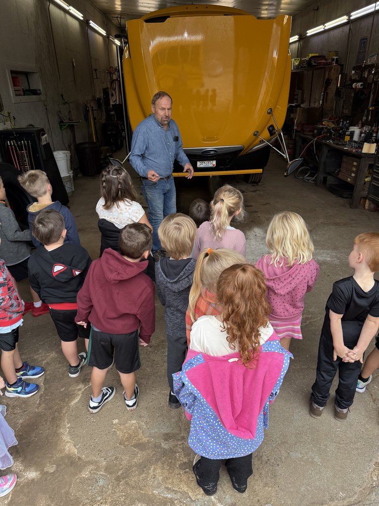 bus driver and students in front of a bus with the hood up