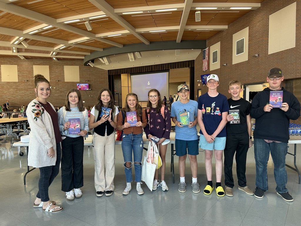 Mrs. Syrstad and 8 students holding books