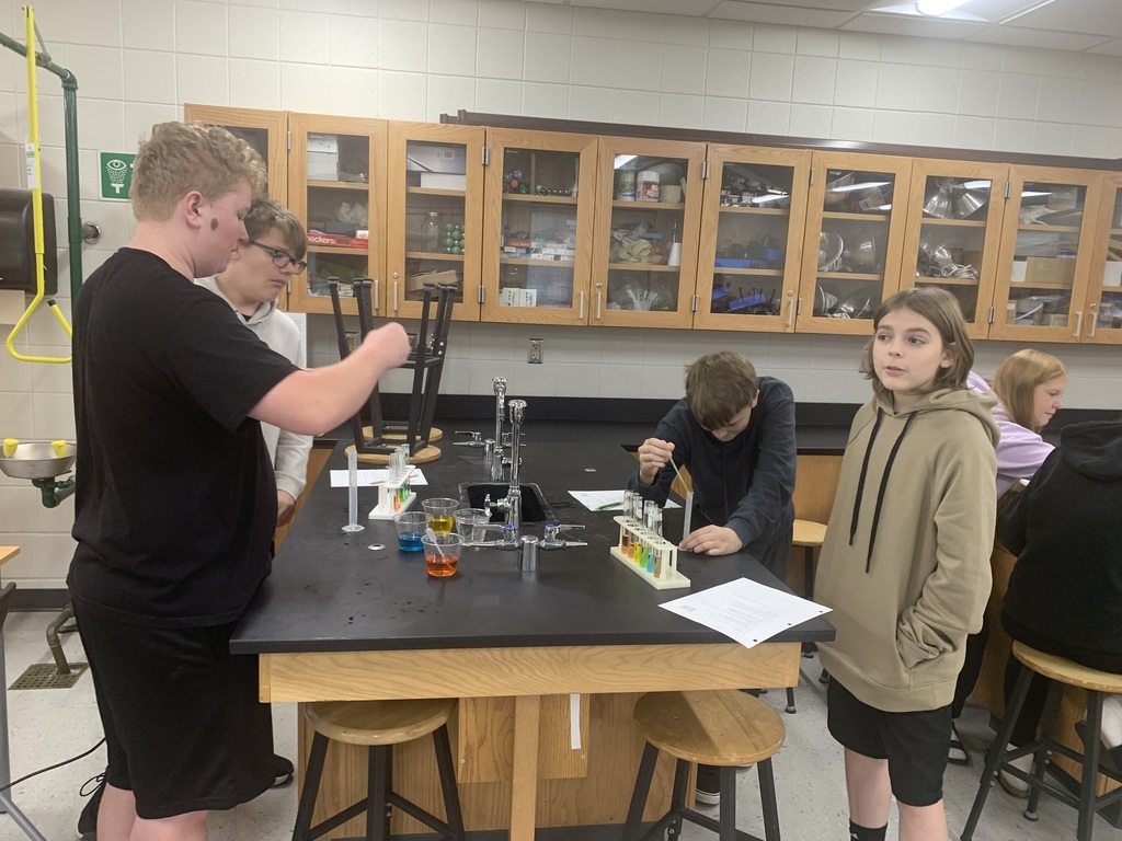 students performing a lab with graduated cylinders
