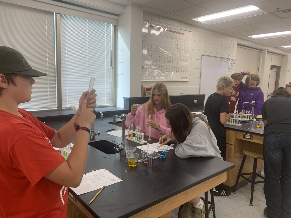 three students working on their graduated cylinder lab