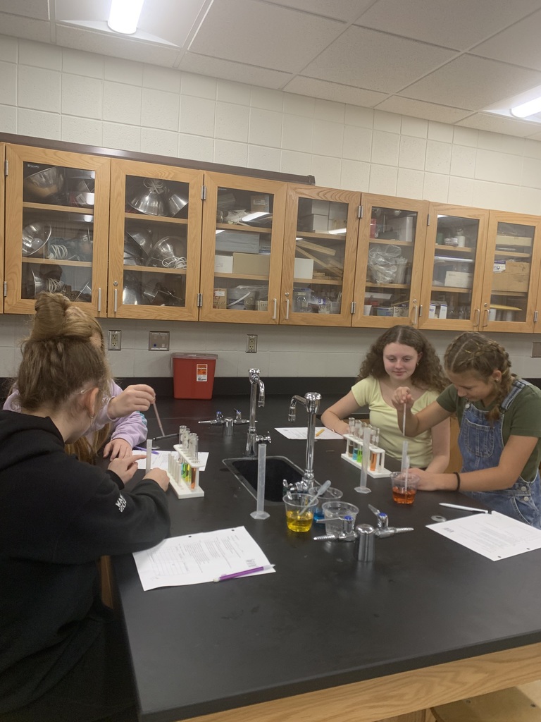 4 girls at their lab table with graduated cylinders
