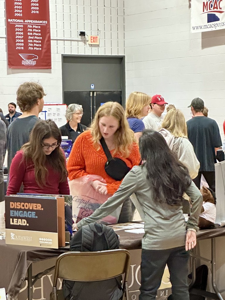2 female seniors in front of a table at the CLC college fair
