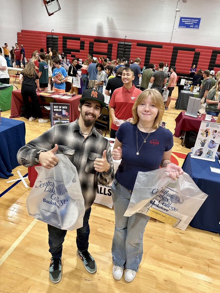 two seniors giving thumbs up with their bags from CLC