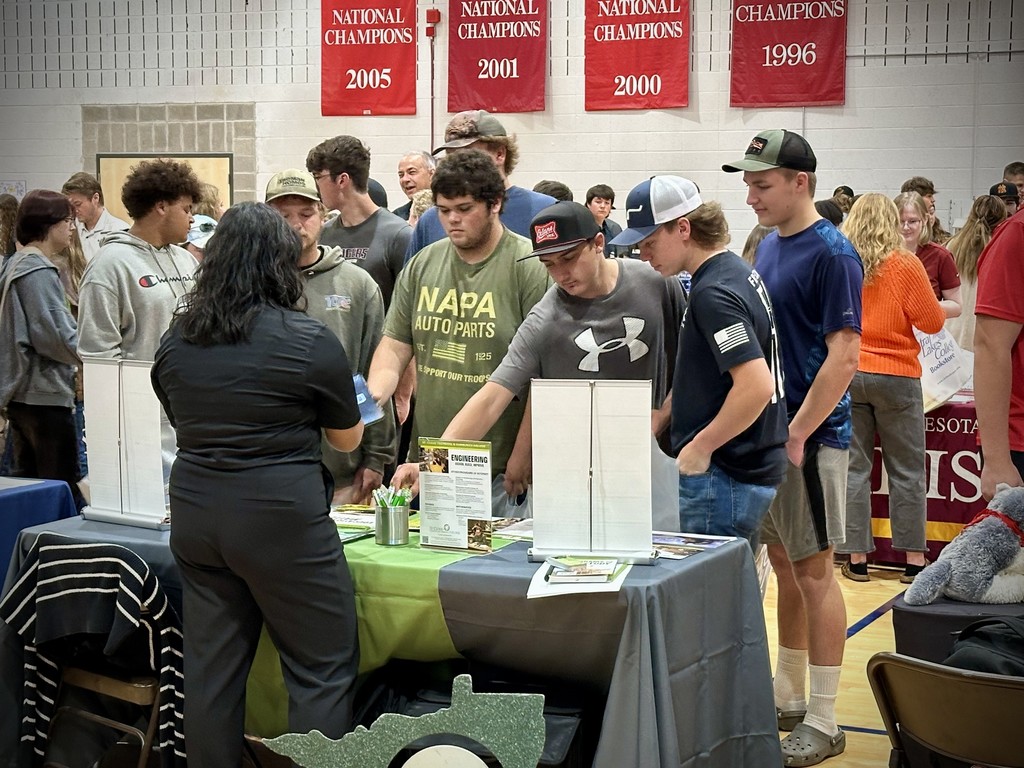 5 male seniors in front of a table at the CLC college fair