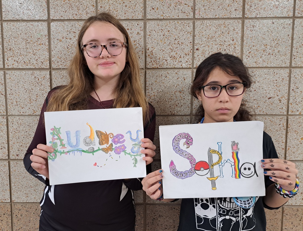 two females holding name art A and S