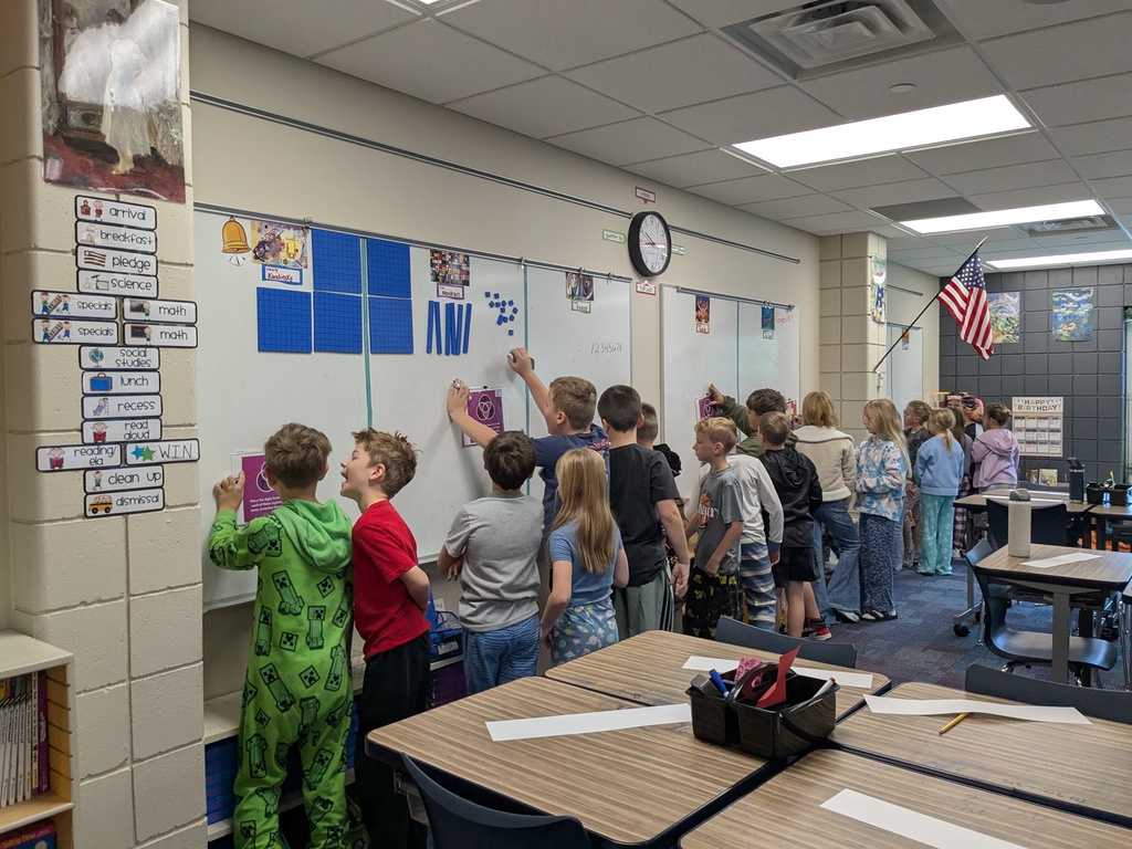 students standing at the marker board working together