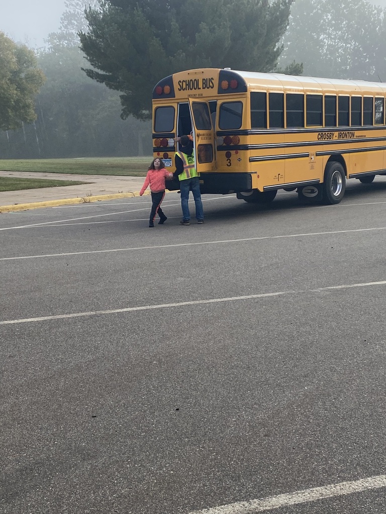 female student getting helped off the back of the bus