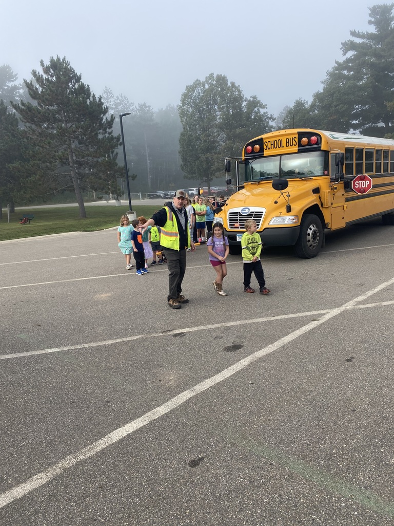 bus driver showing students to look both ways once past the bus