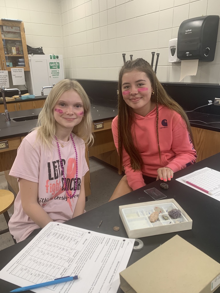 two females sitting at a lab table with minerals in front of them