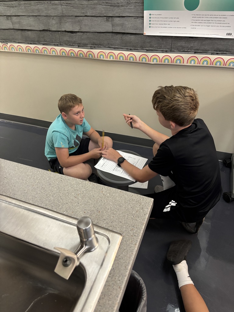 one male student talking to another male student about their worksheet
