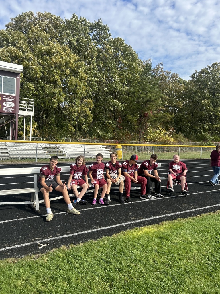 unified partners and special olympics foootball players sitting on a bench