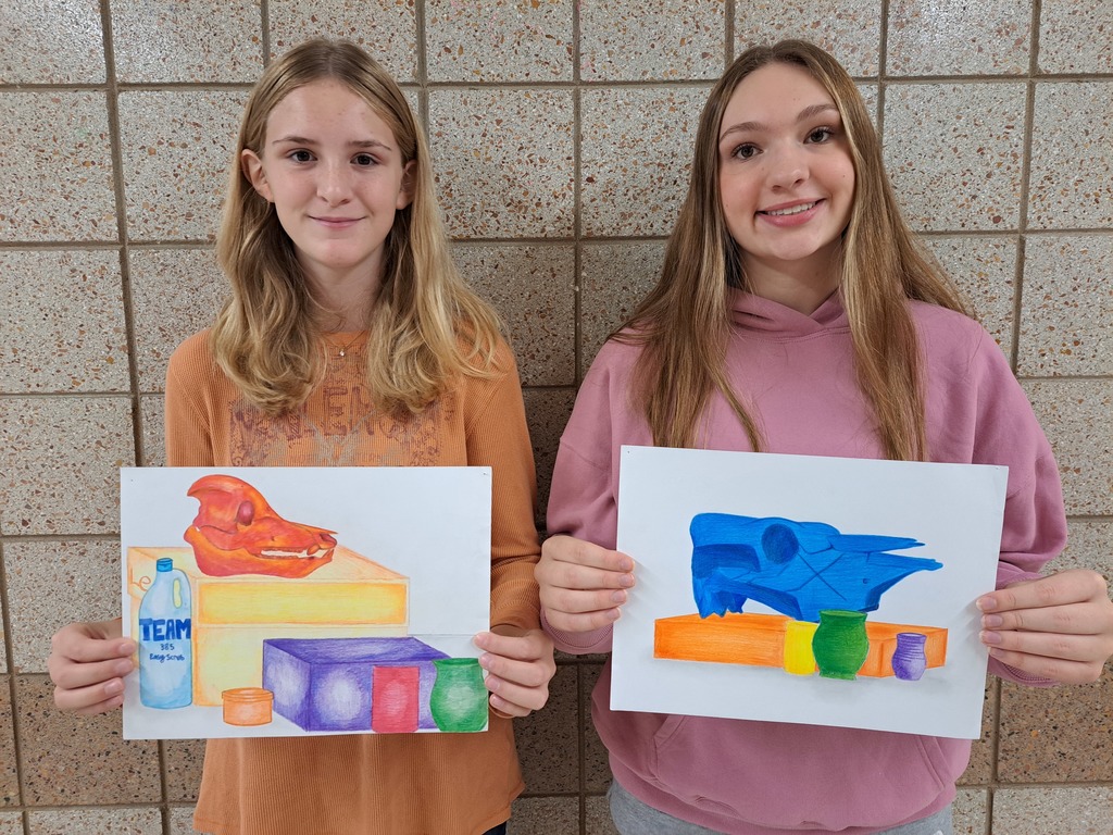 two females holding colorful paintings