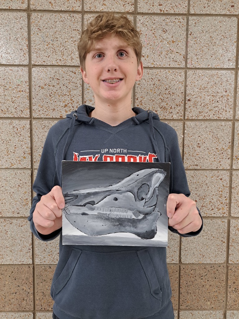 Male student holding a painted black and white skull