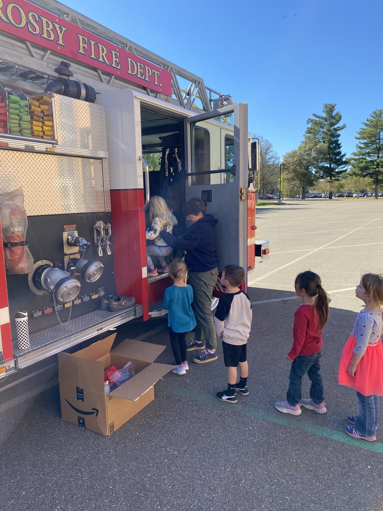 young students getting helped onto the fire truck for a tour