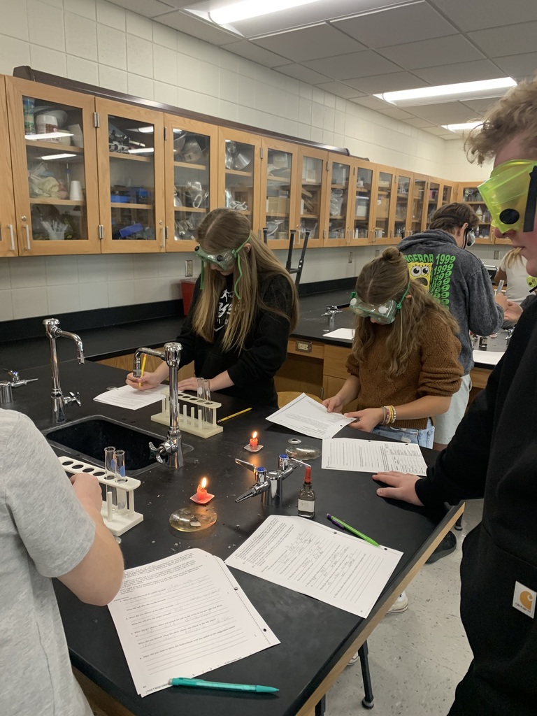students at their lab table with candles burning working on their worksheets