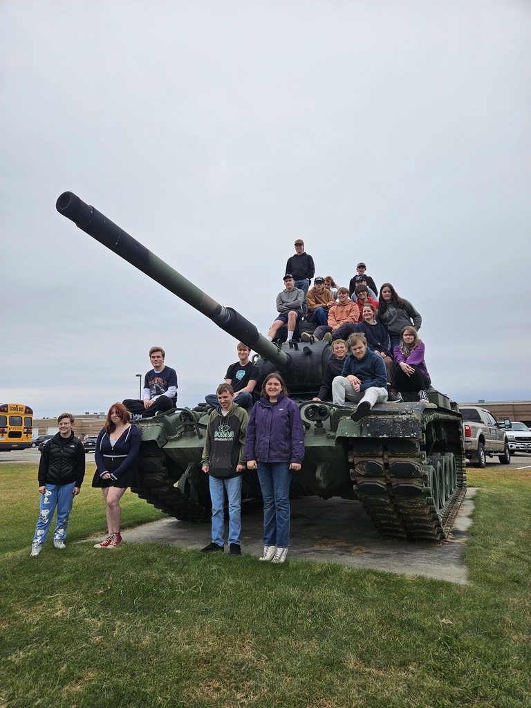 C-I students sitting on an army tank at Camp Ripley during their tour