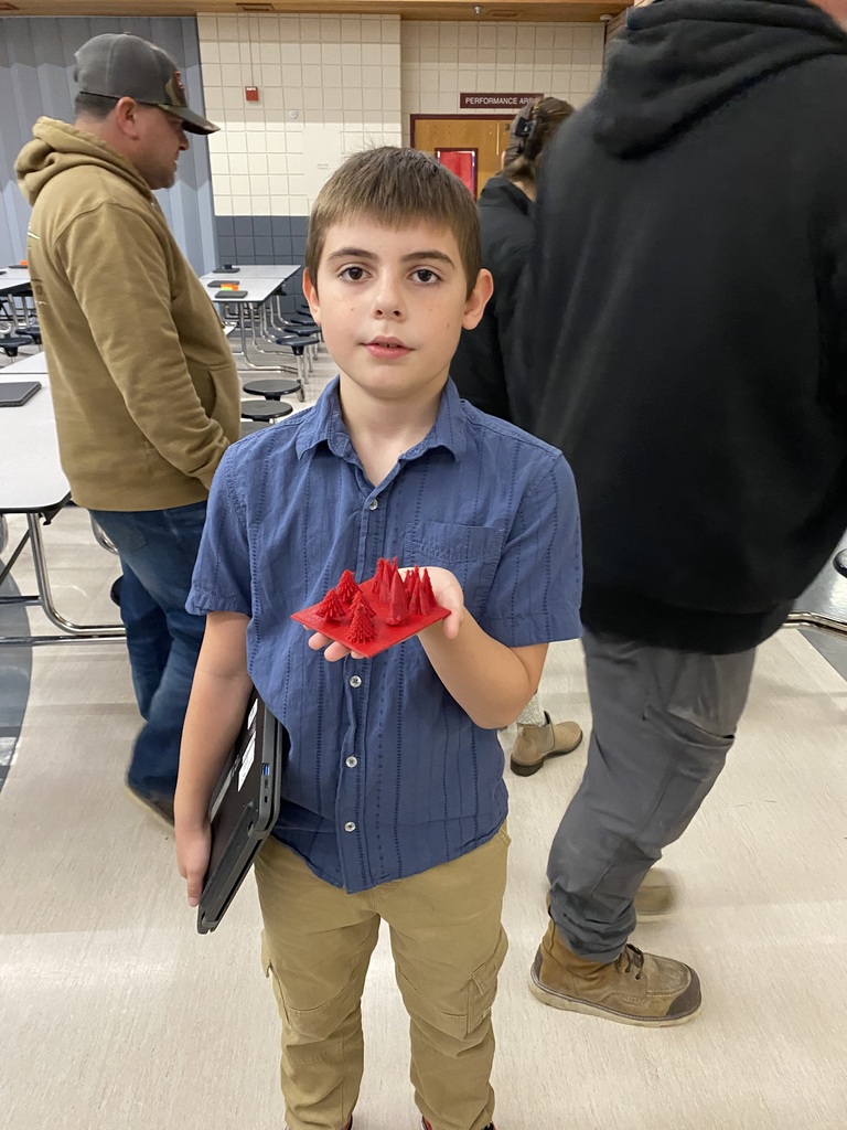 student holding a 3d print of trees