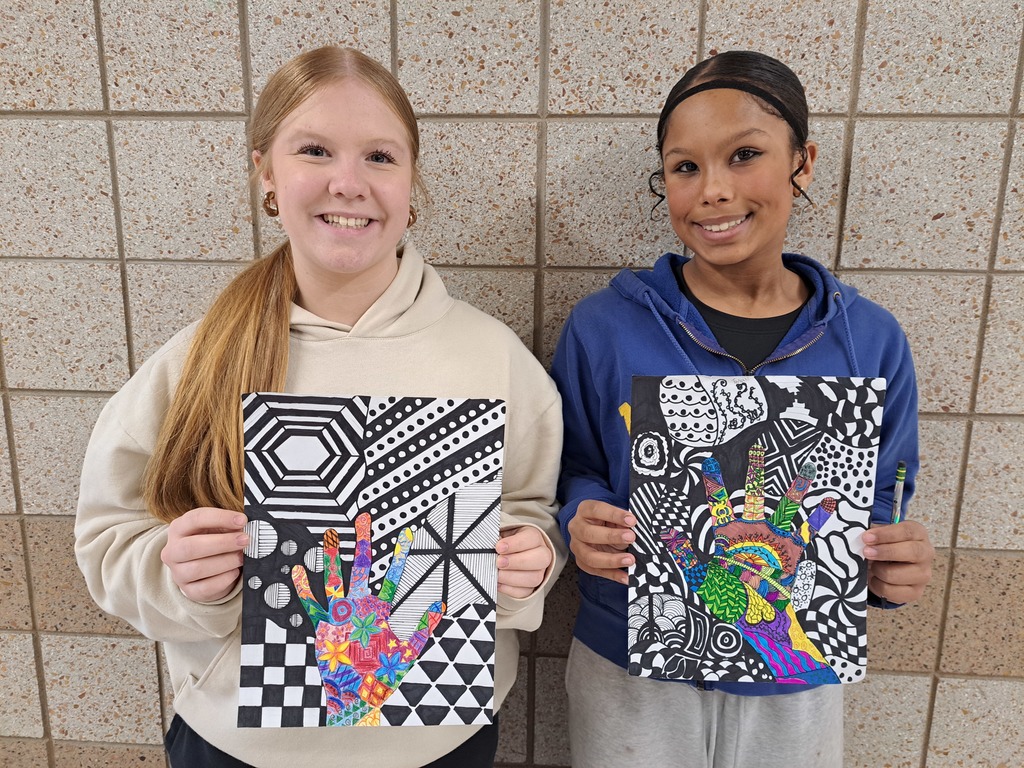 two female art students holding their hand art drawings