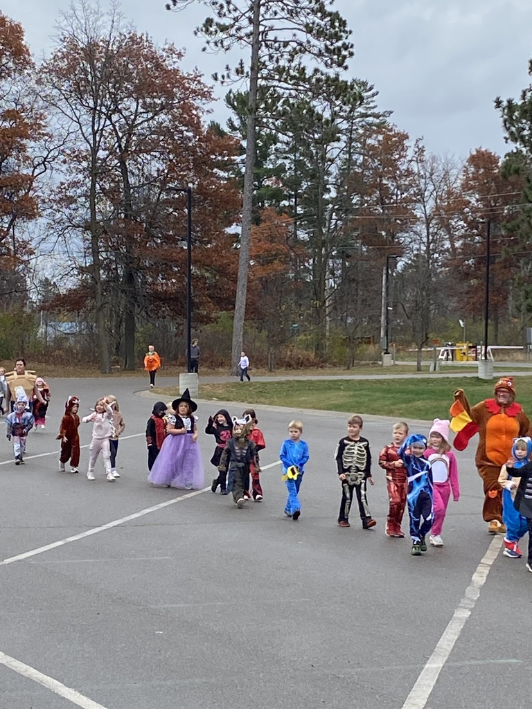 Kindergartners in their Halloween costumes walking in a the parade