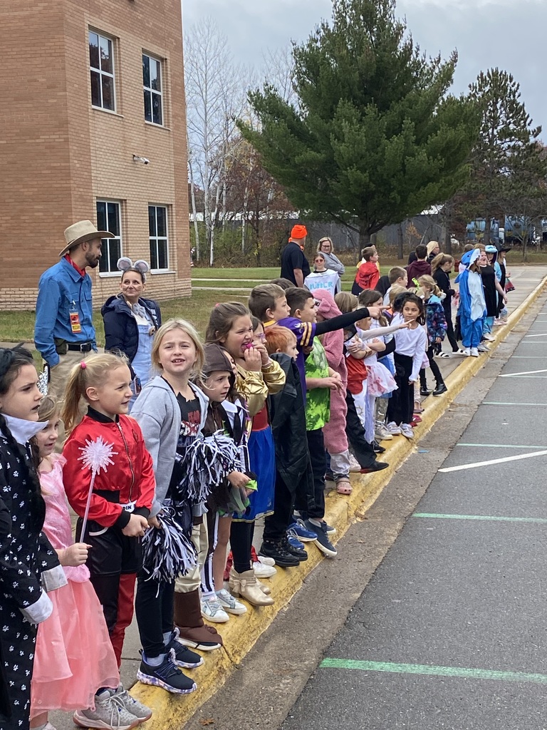 CRES students lined up on the sidewalk wearing their Halloween costumes watching the Halloween parade