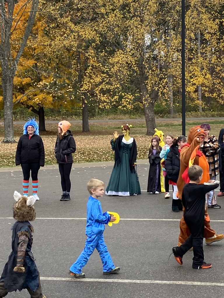 studnets walking around the bus loop in their Halloween costumes- someone is dressed like Fiona from Shrek