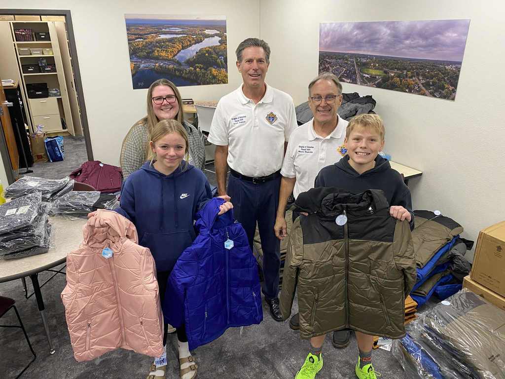 students holding new coats along with our family collaborative worker and two of the Knights of Columbus council members for Coats for Kids. 