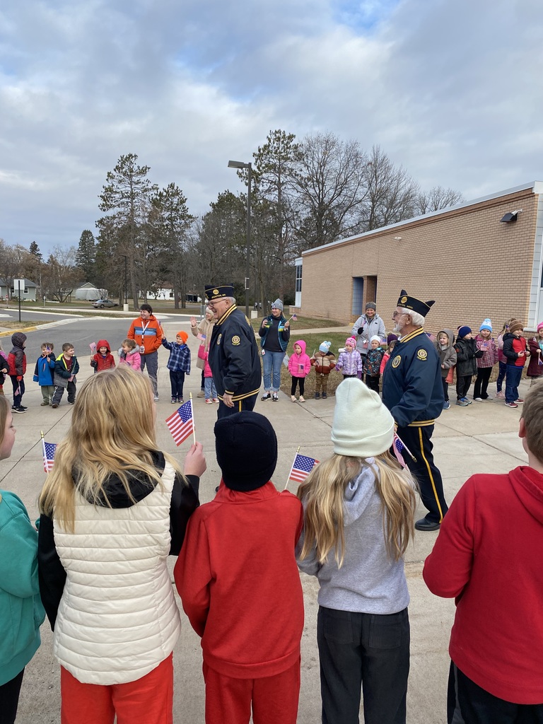 students at CRES lining the sidewalk and waving their American flags as our local veterans walk through them on Veteran's Day