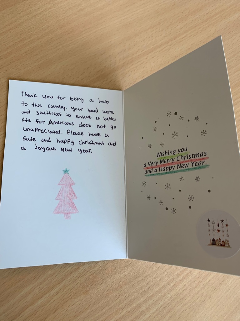 Holiday for Heros card with a red hand drawn christmas tree and a handwritten message. The inside of the card says "wishing you a Merry Christmas and a Happy New Year."