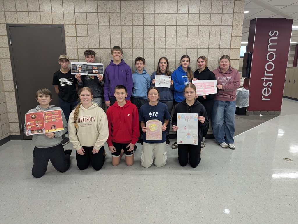 Another group of 8th graders holding up their menus from 8th grade English class