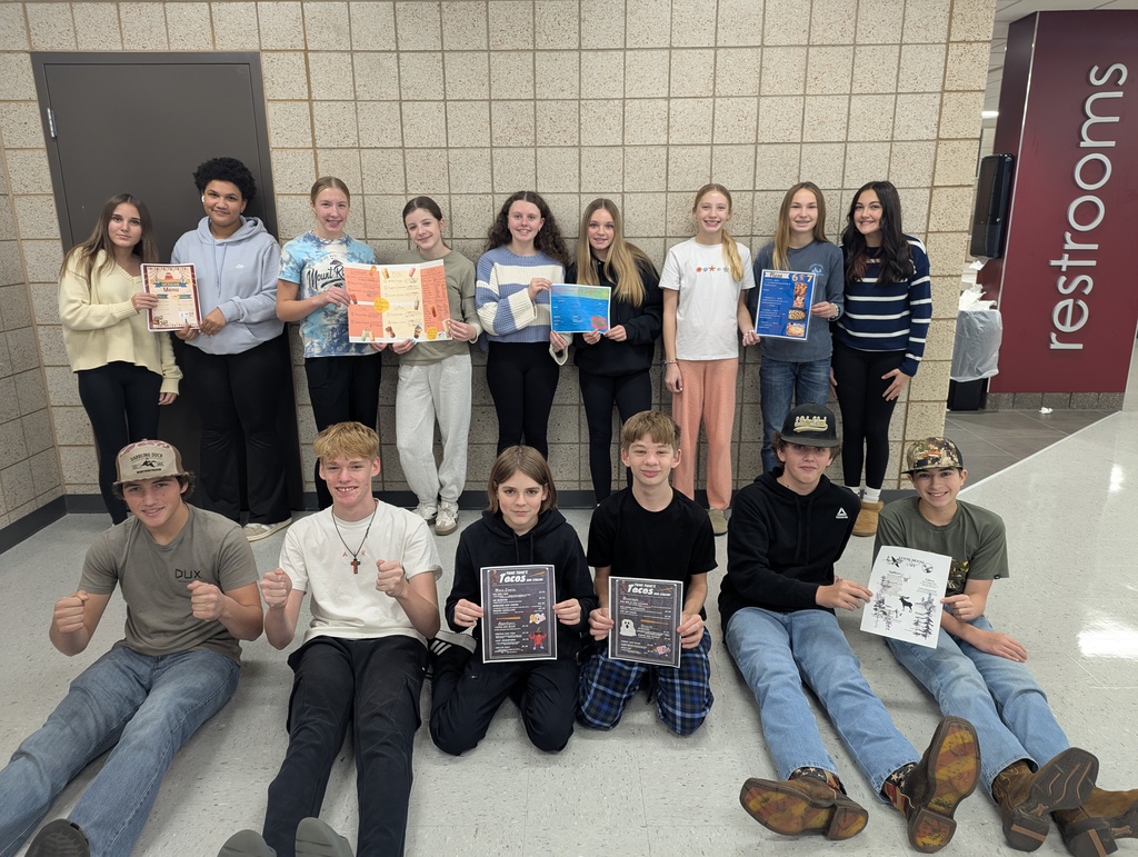 8th grade students holding thier created menus from English Class with Mrs. Larson