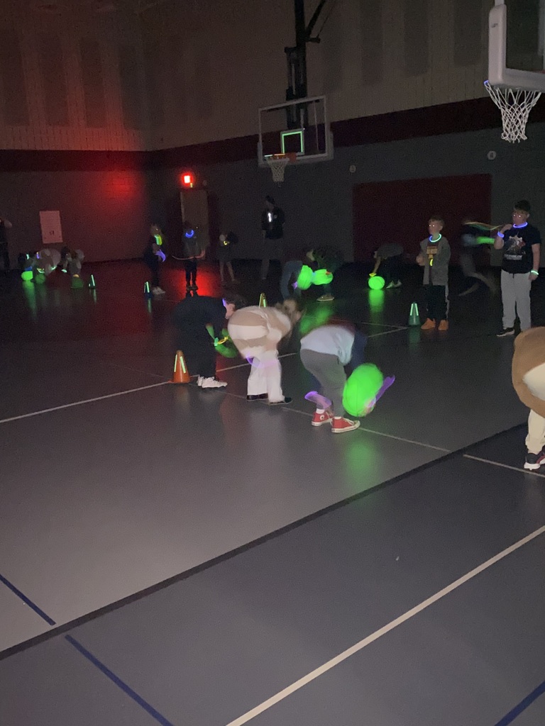 3rd greade students dribbling green glow in the dark basketballs during their expo
