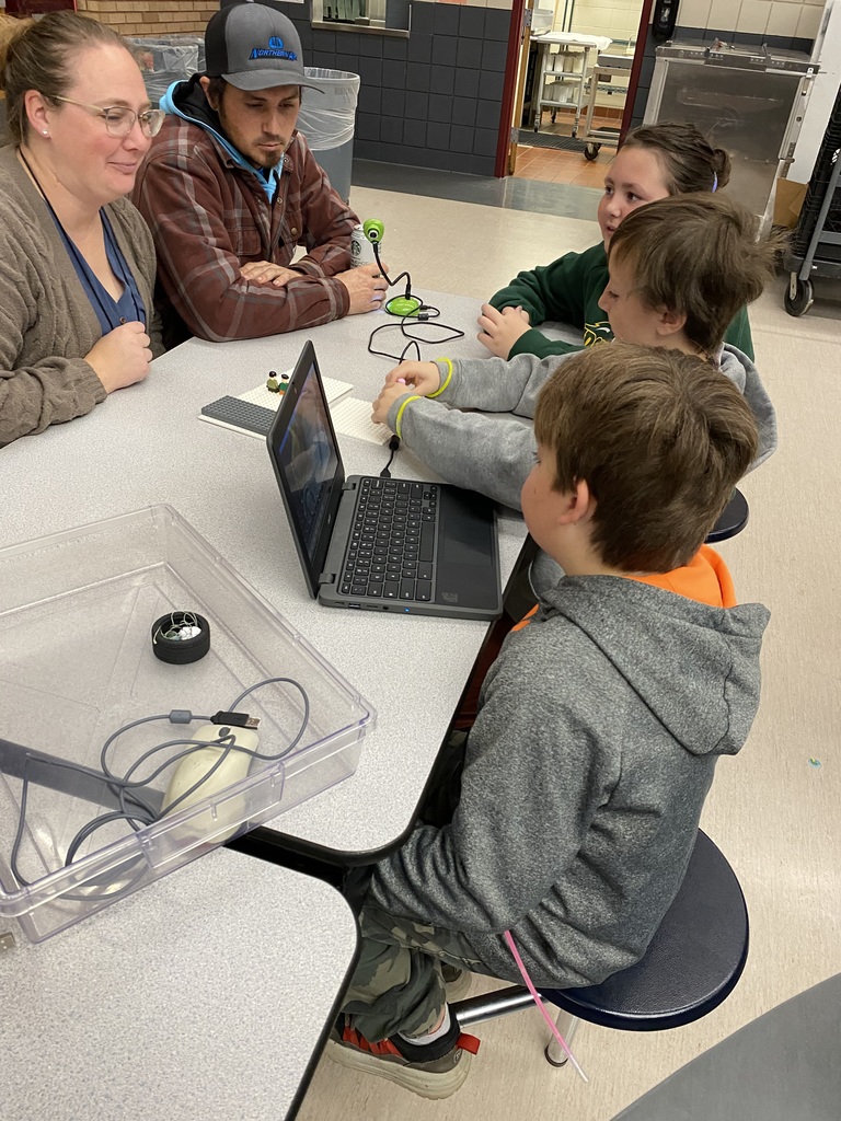three third graders showing two adults their computer movie that they made for their expo