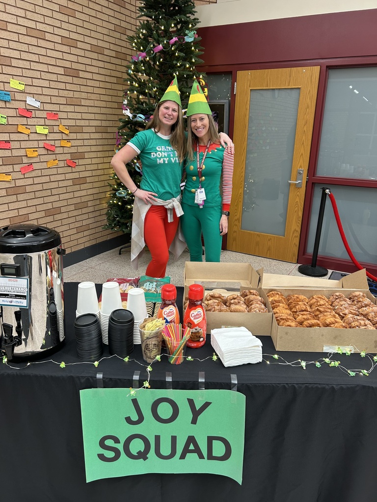 Joy Squad, two female staff members, posing behind donuts and coffee that they provided for staff at CRES