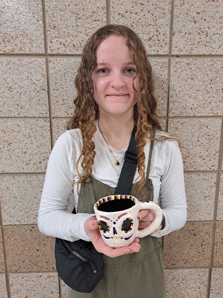 Female student holding a skull , 3D face mug that she made in 3D art class